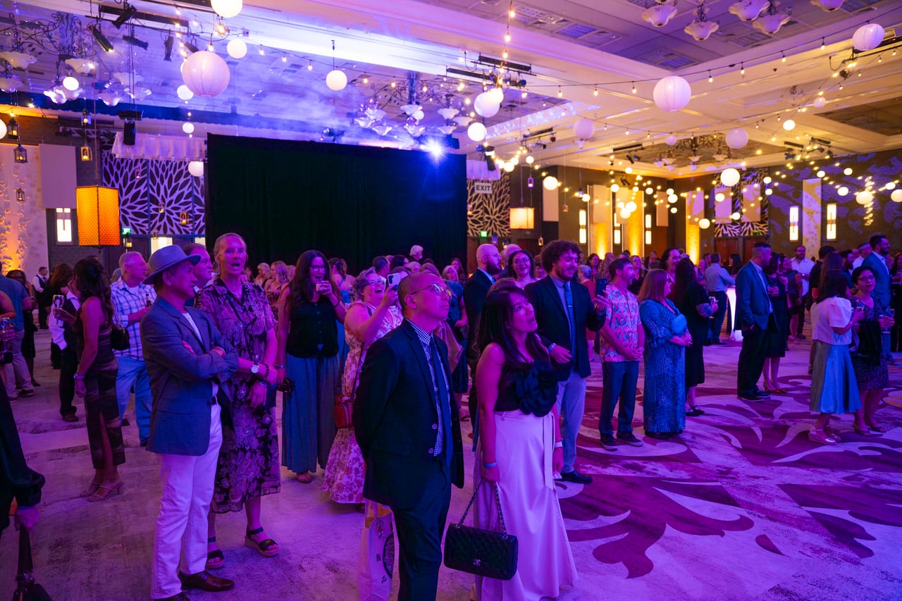 Renown guests gathering on the dance floor under the globe lights and string lights