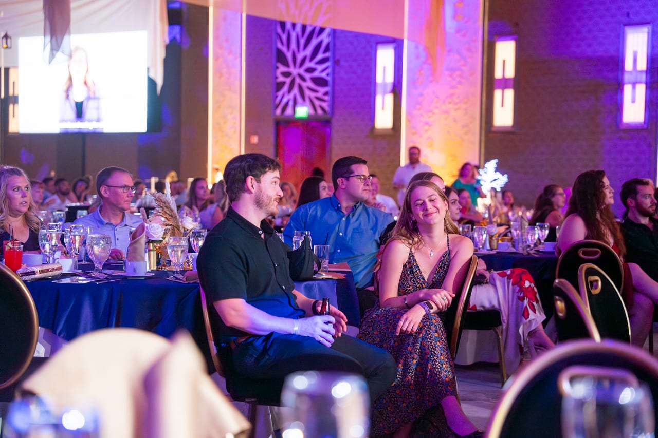 Renown guests laughing together at their table during the program
