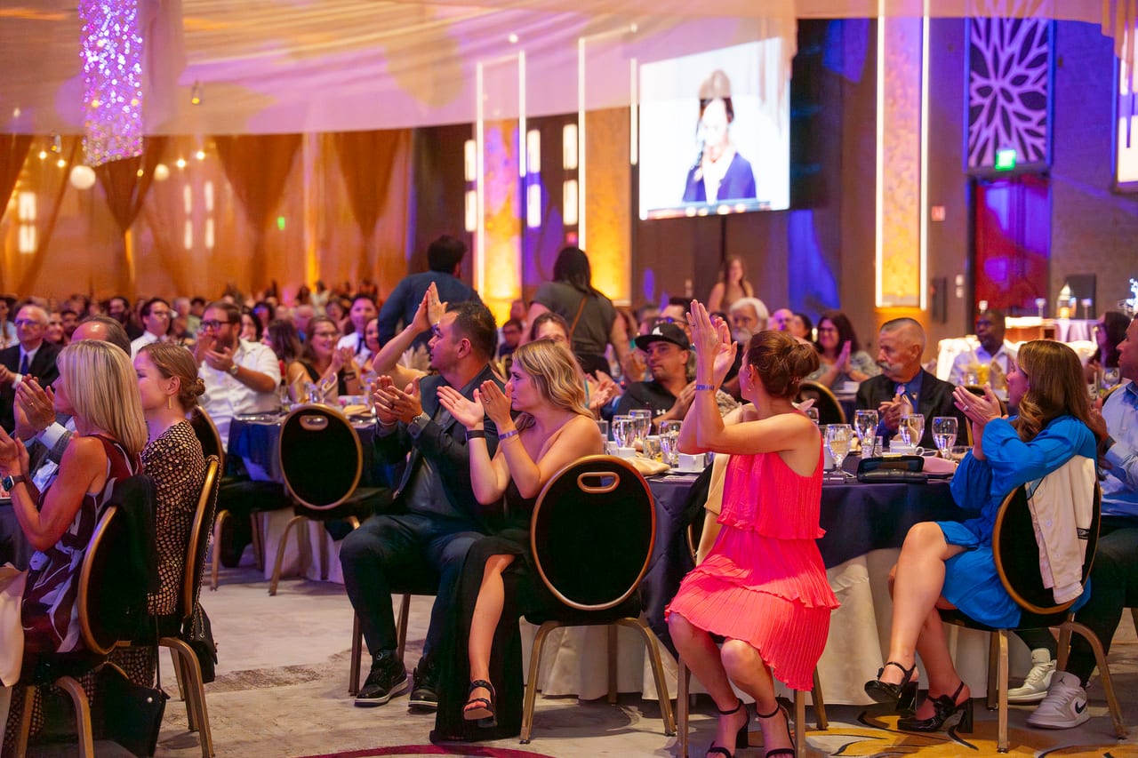 Renown guests on their feet cheering a colleague from their tables