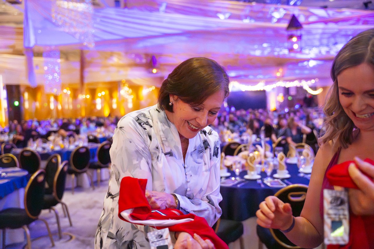 Two Renown guests laughing as they open their prizes