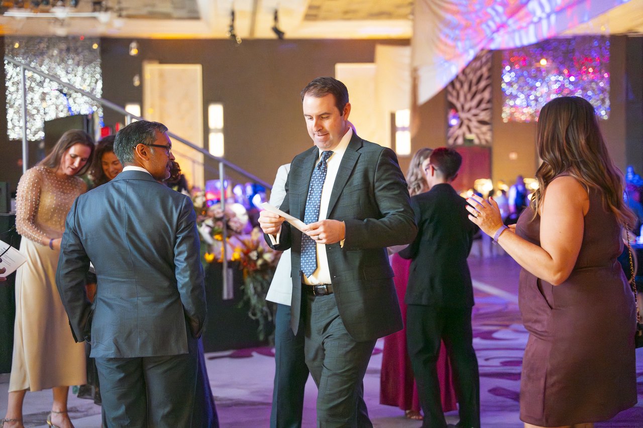 Renown guests reading their raffle tickets on the dance floor