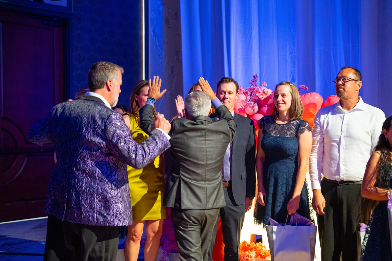 The emcee giving high fives to Renown honorees in front of the stage