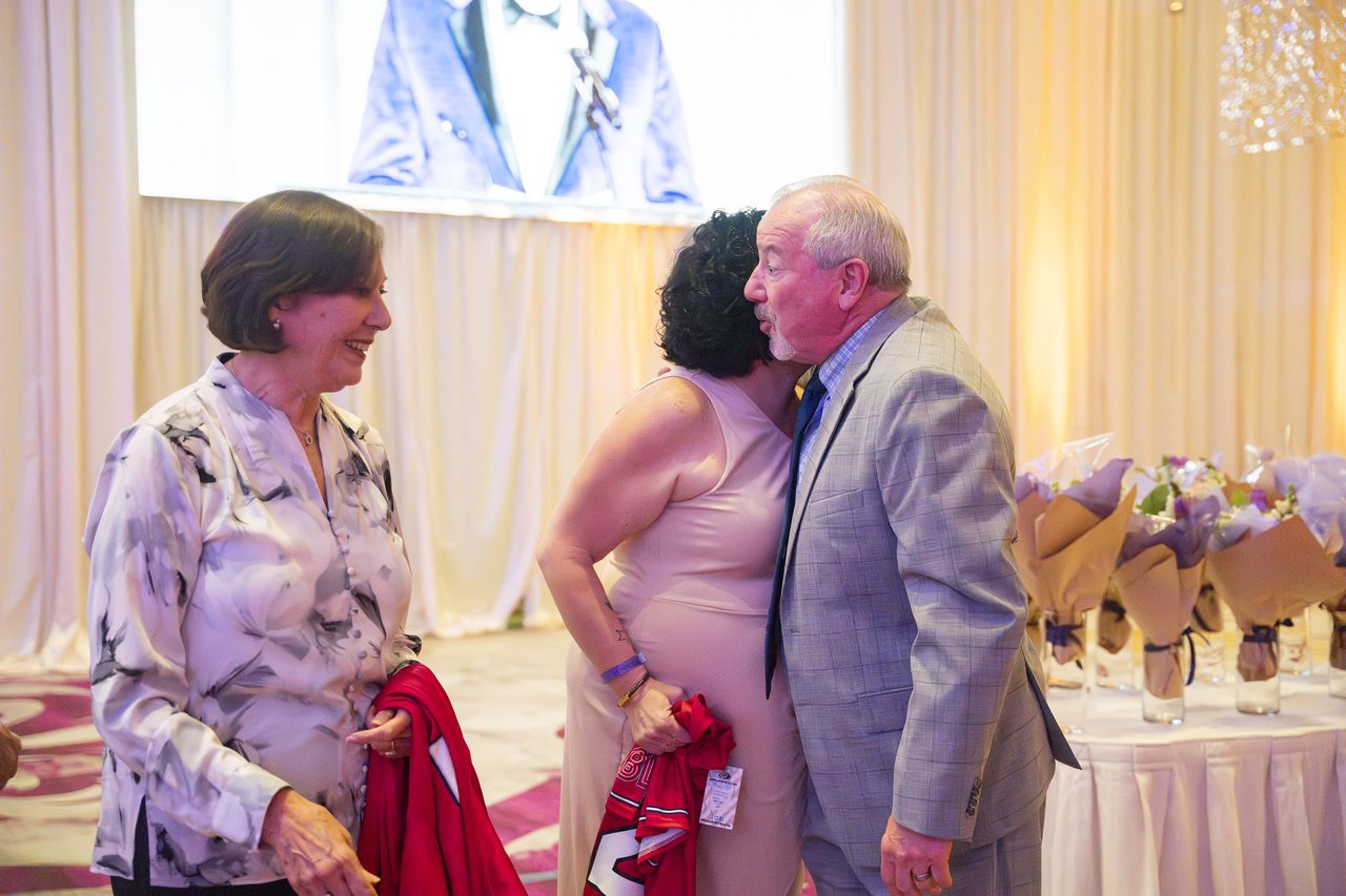 A Renown leader greeting an honoree with a kiss on the cheek