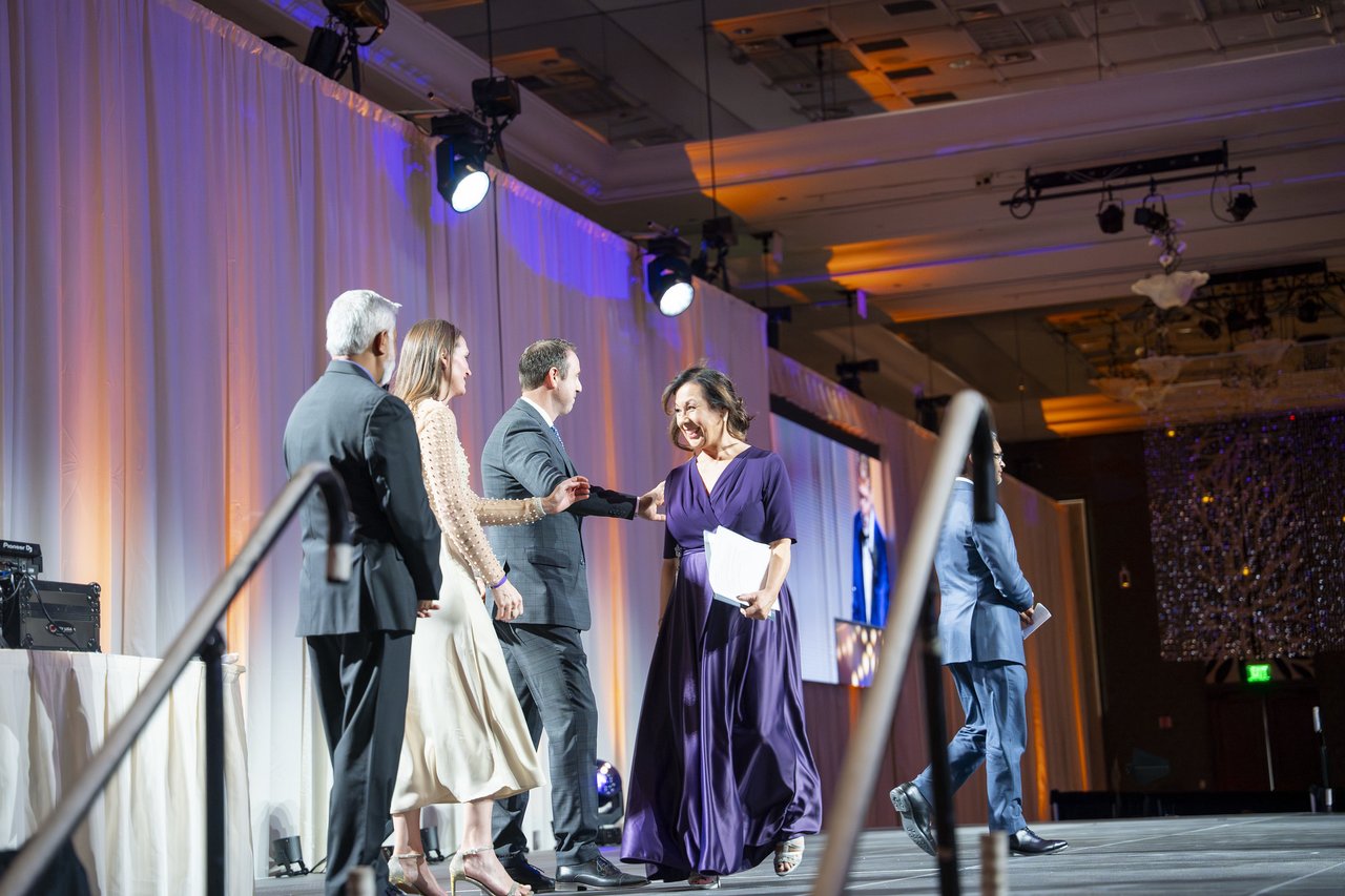 A Renown honoree greeted by leaders on stage