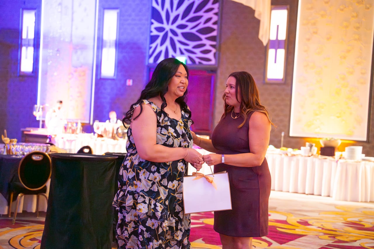 A Renown honoree receiving a gift bag from a coworker