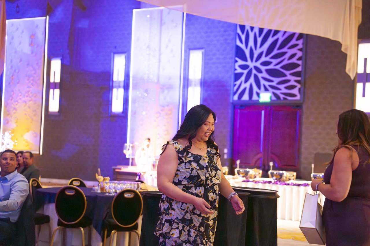 A Renown honoree smiling as she walks past the tables