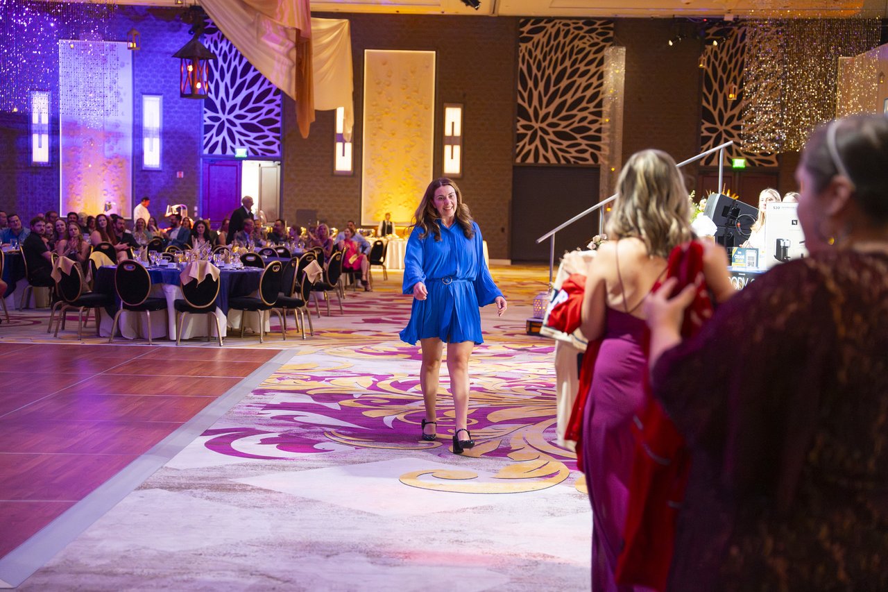 A Renown honoree in blue walking across the ballroom