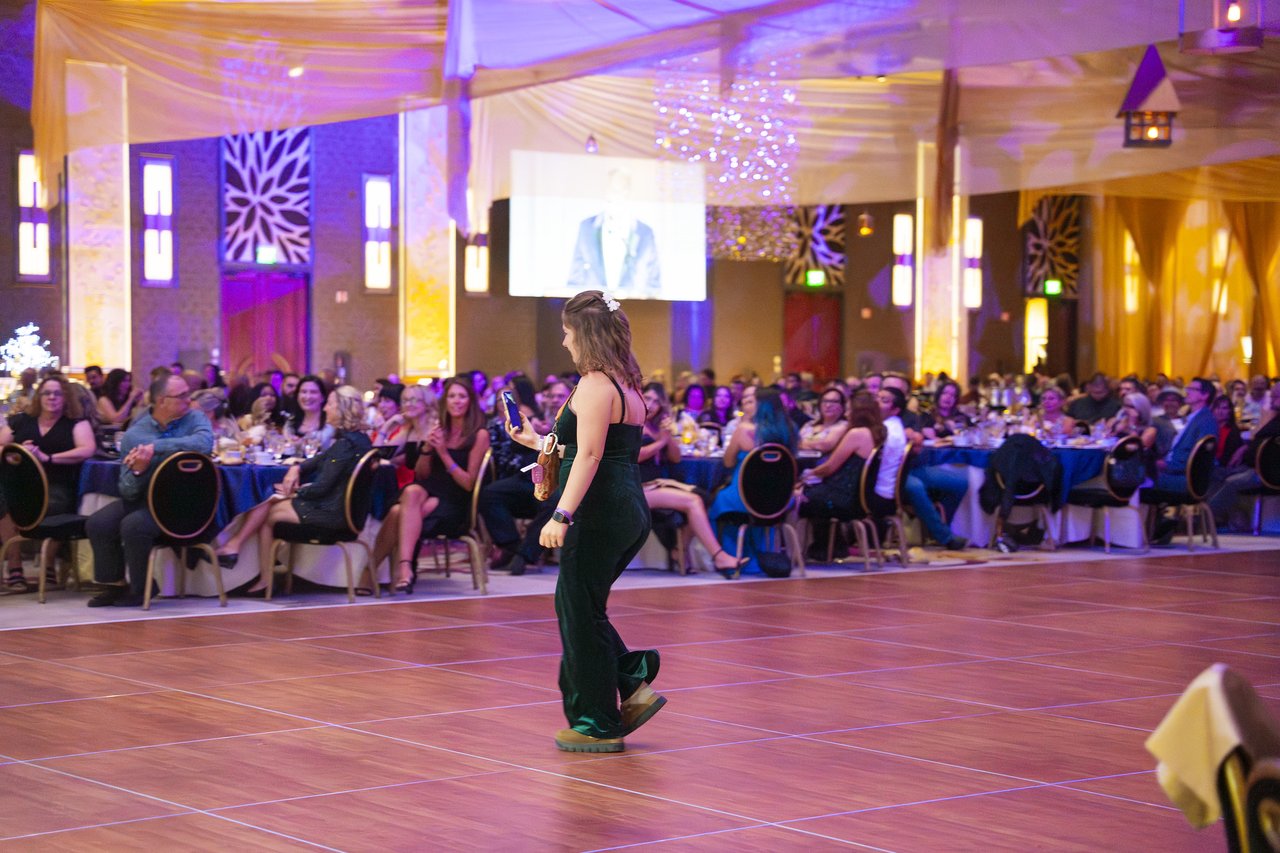 A Renown honoree walking across the dance floor to the stage