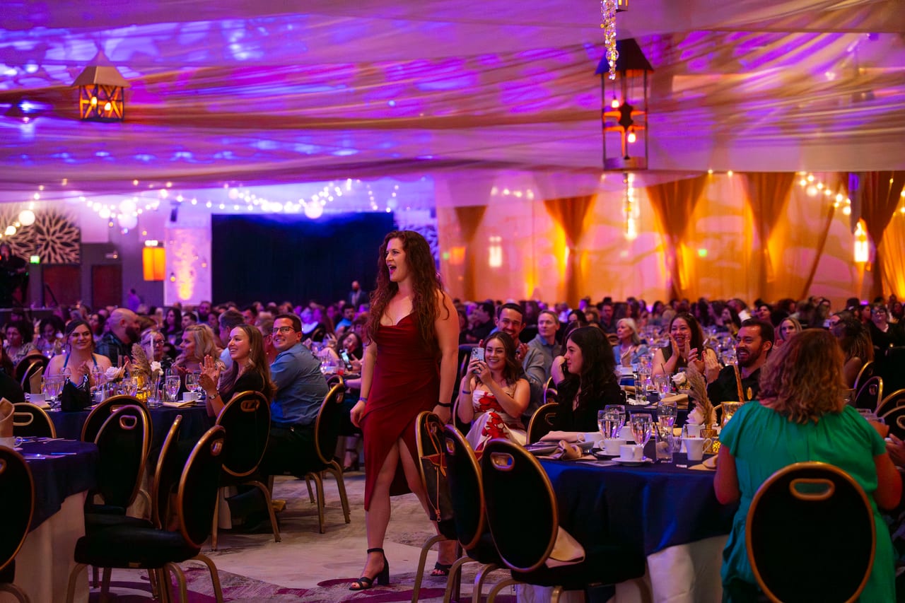 A Renown honoree walking up to cheers through the packed tables