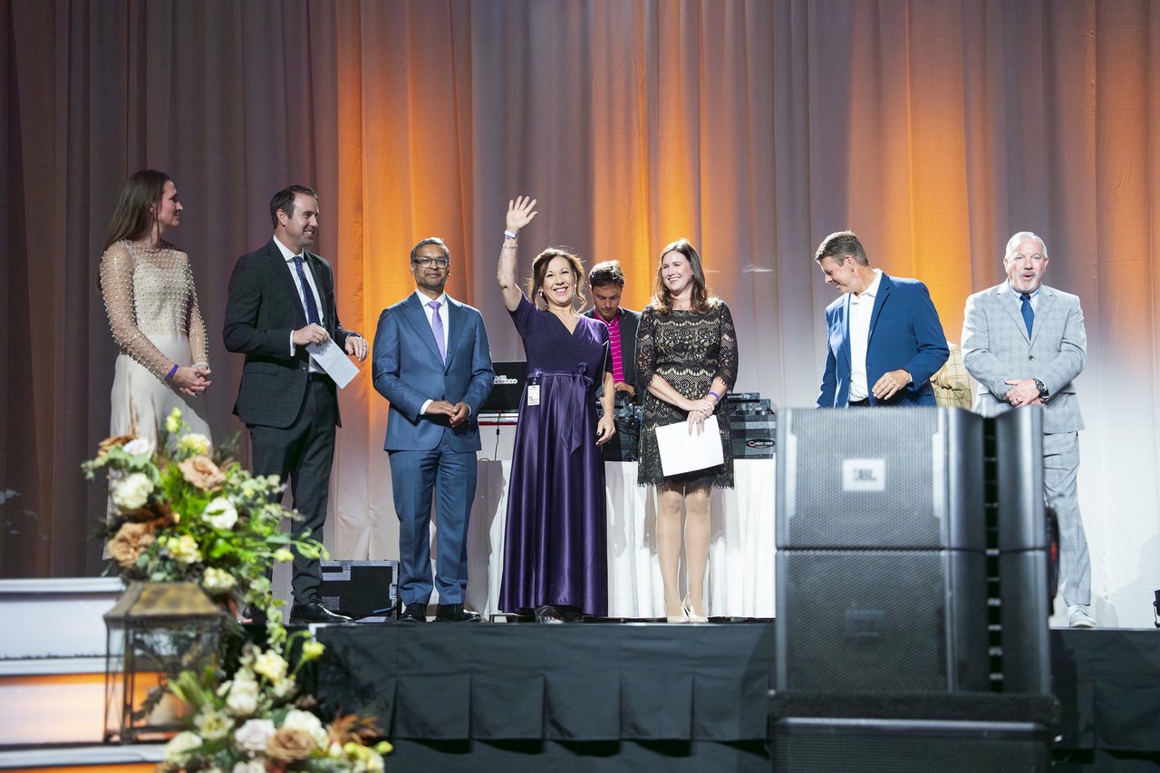 A Renown honoree waving to the crowd from the stage