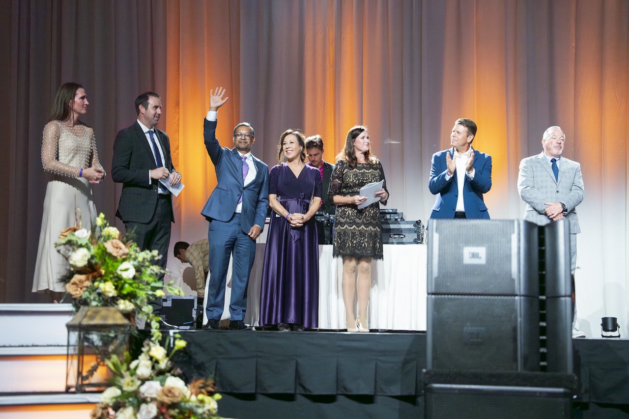 A Renown honoree waving from the stage with the other honorees