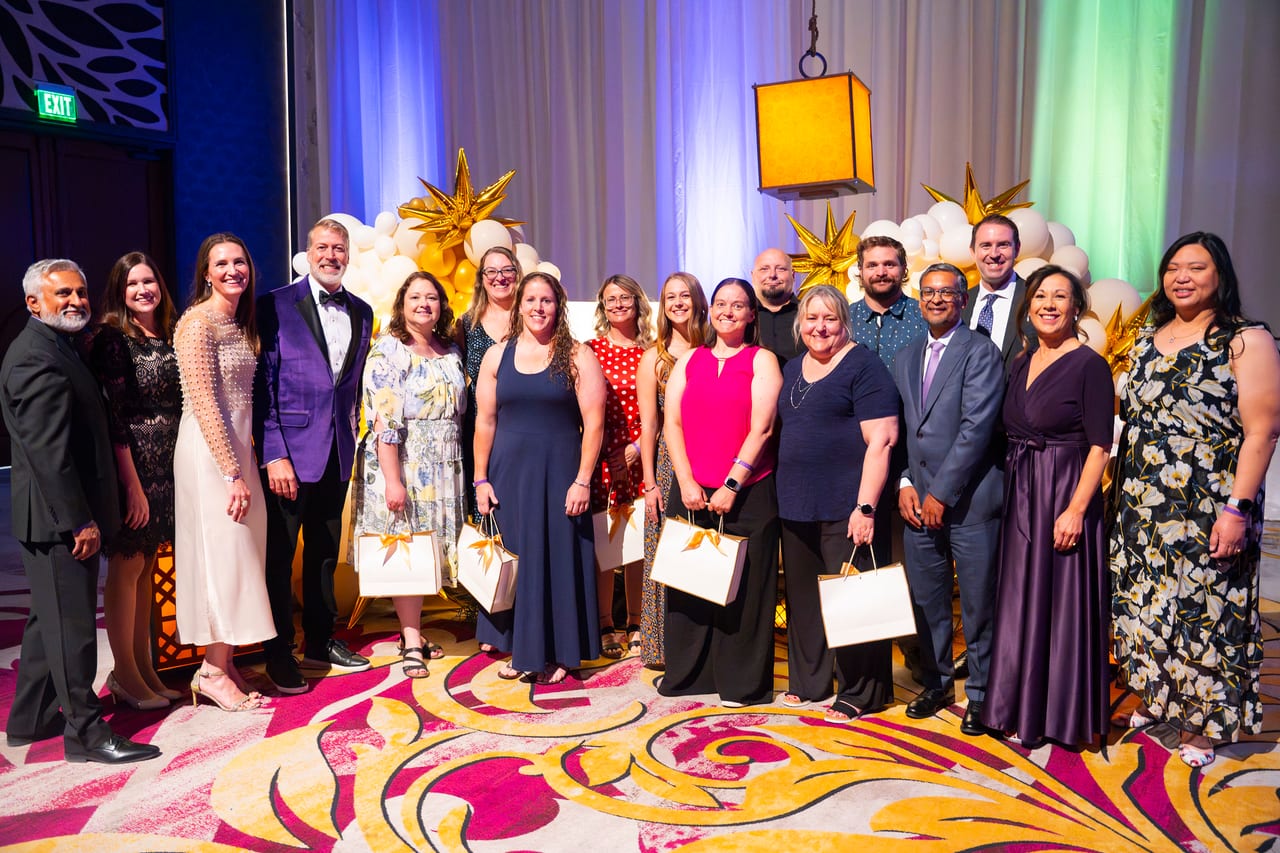 Renown honorees and leaders together on stage with their gift bags