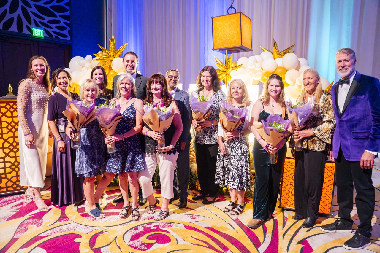 Renown honorees with bouquets and the host at the balloon arch