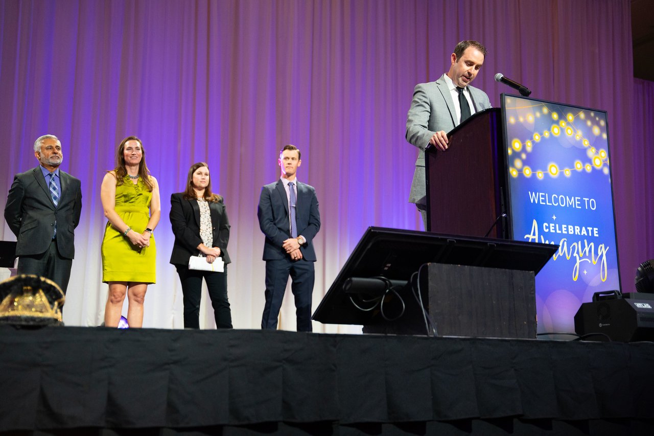 Renown honorees standing beside the podium as the host speaks