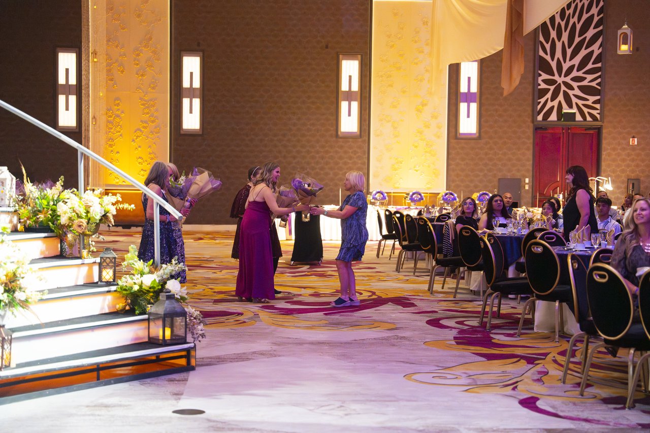 Renown honorees heading toward the stage stairs with their bouquets