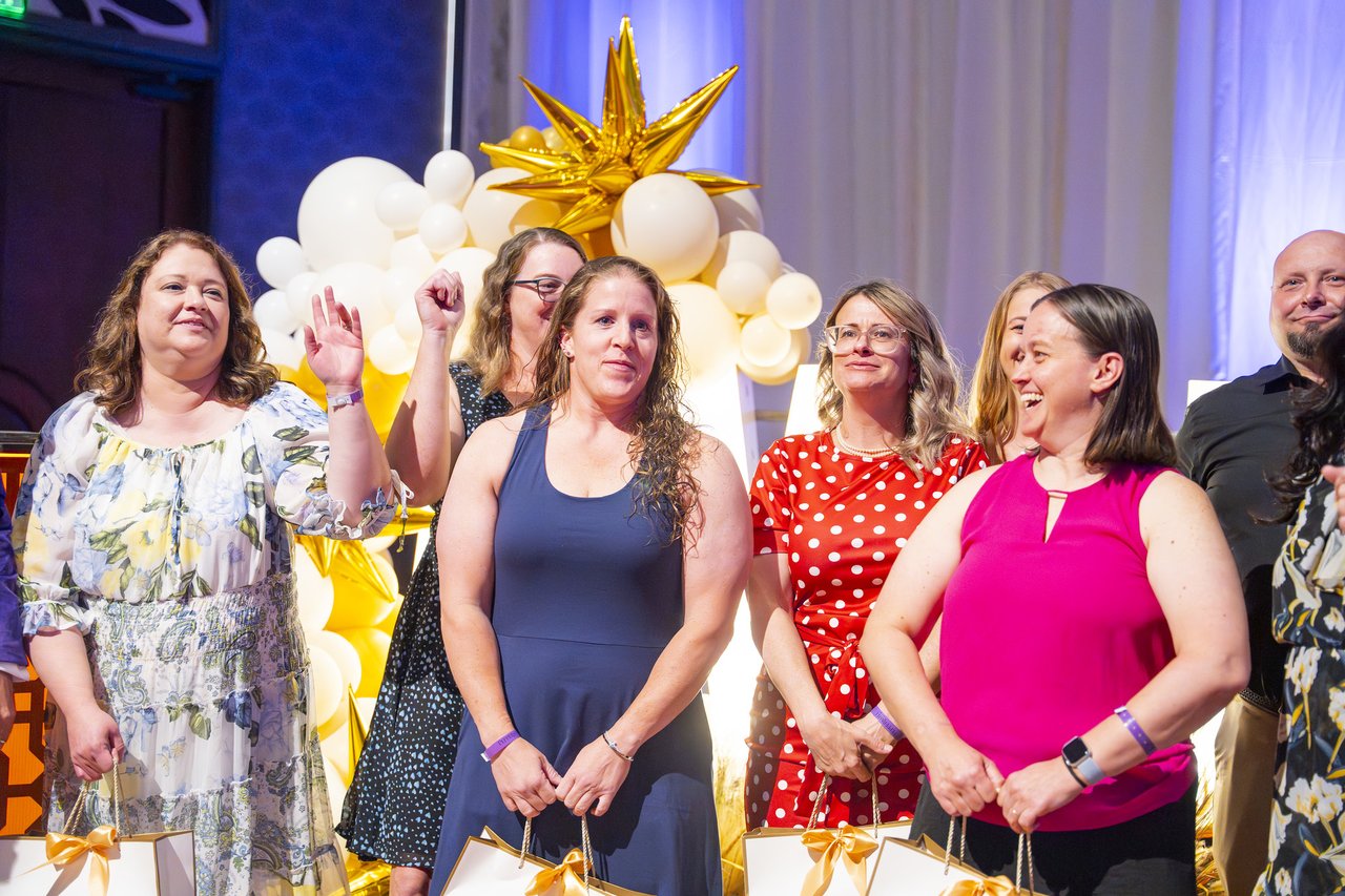 Renown honorees laughing together at the gold balloon arch