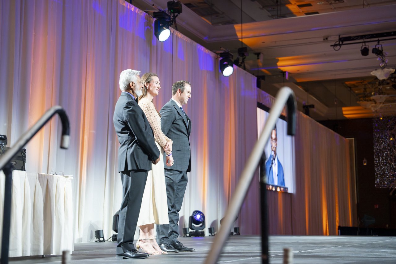 Renown honorees waiting on stage beside the big screen