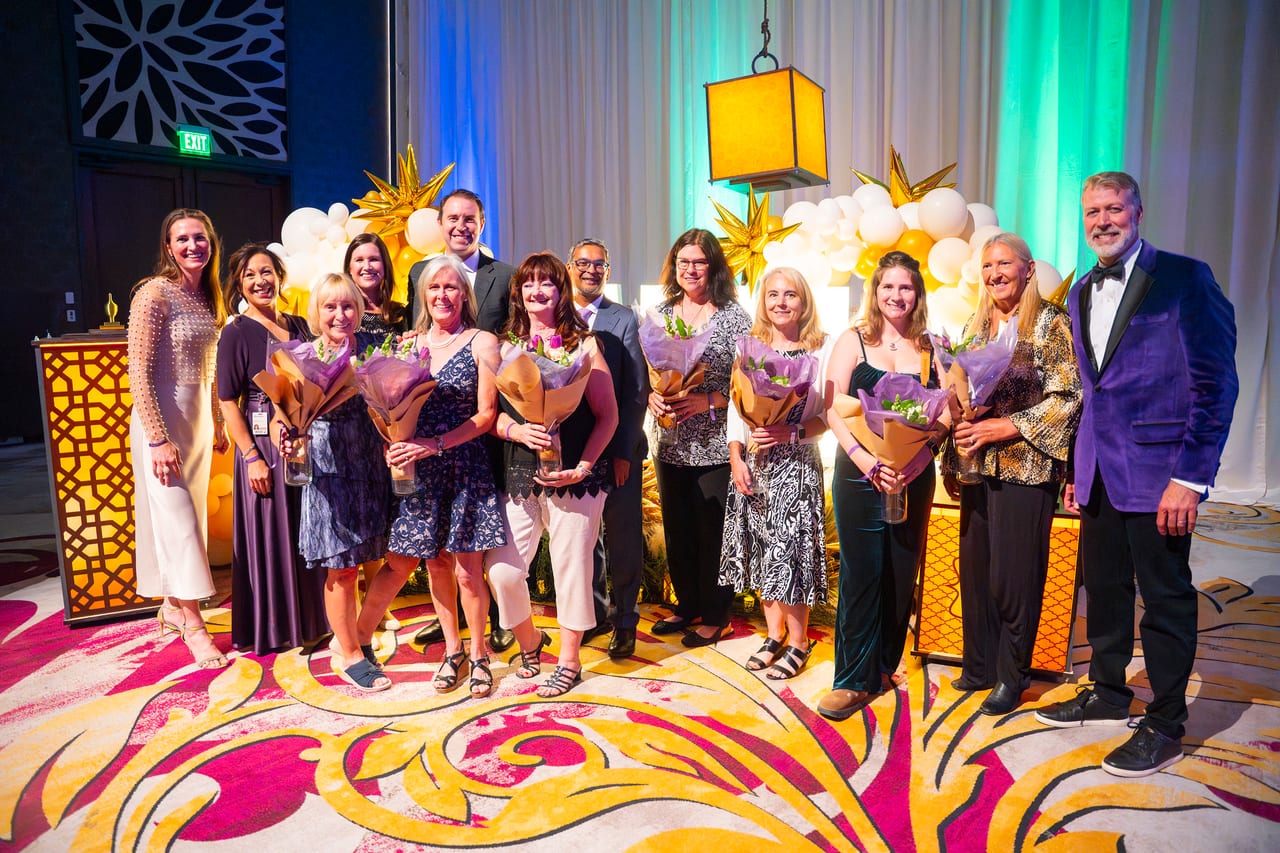 Renown honorees holding bouquets in front of the gold balloon wall