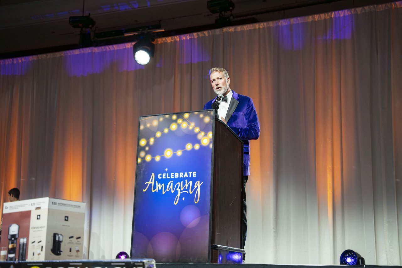 The host speaking at the Celebrate Amazing podium
