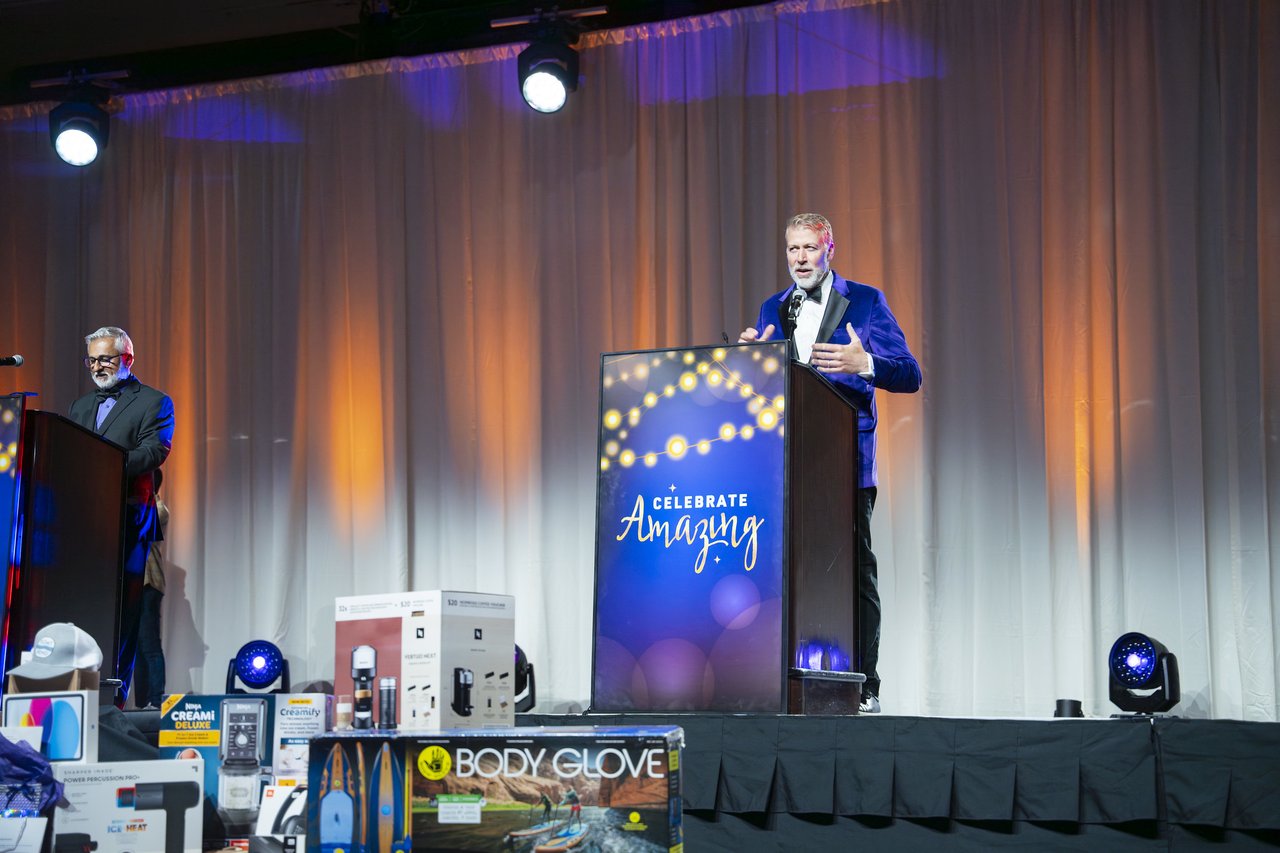 The host laughing at the Celebrate Amazing podium