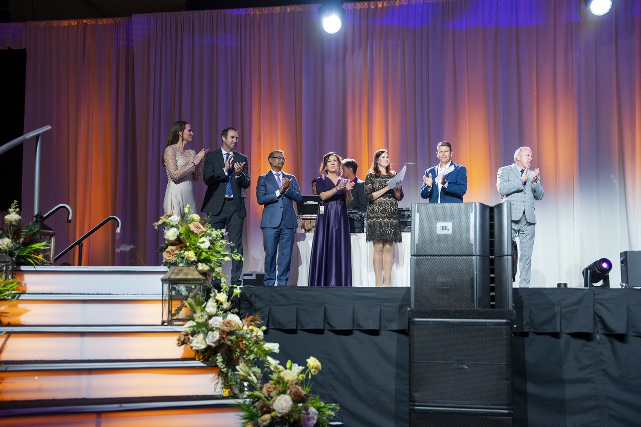 Renown leaders on stage above the lit stairs