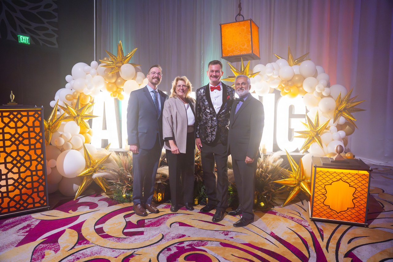 Renown leaders posing in front of the Amazing letters