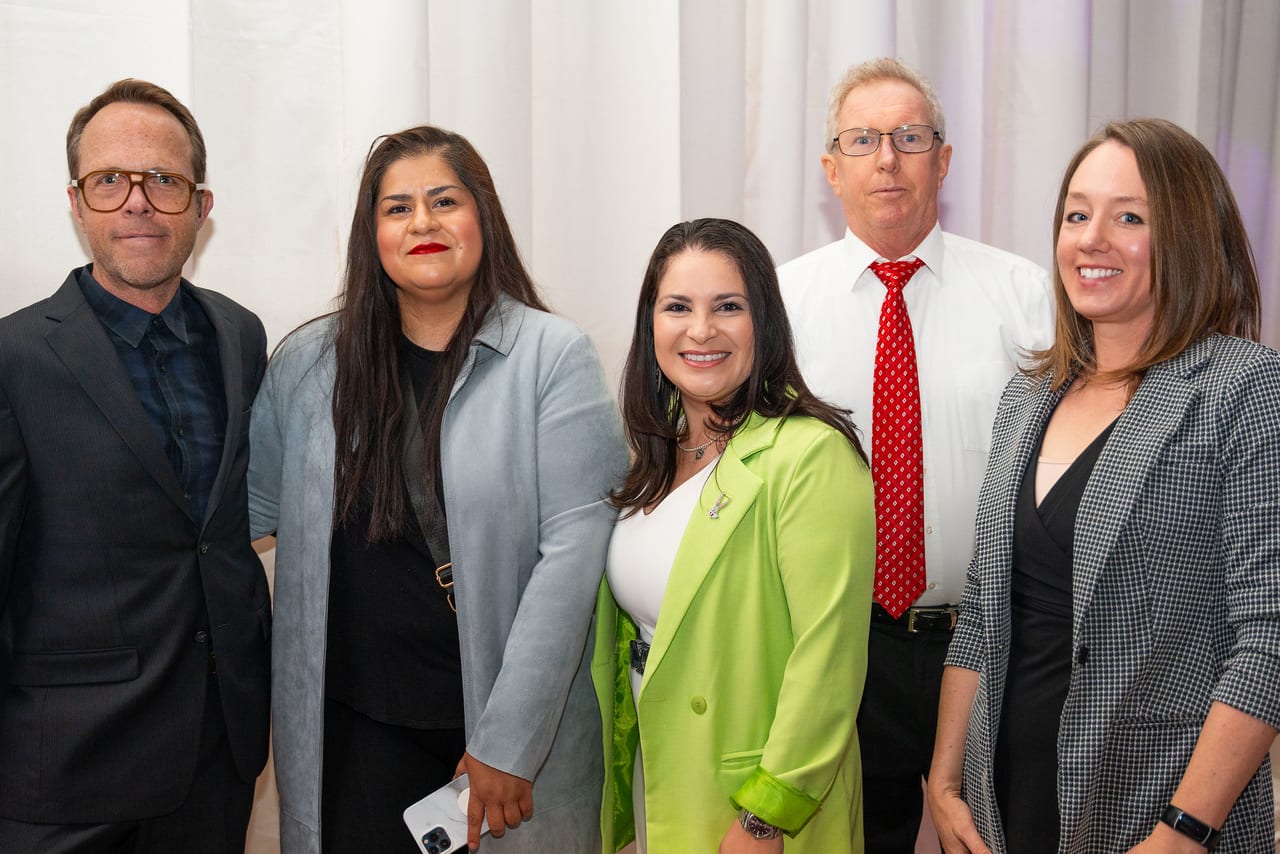 Five Renown leaders smiling together in front of a white backdrop