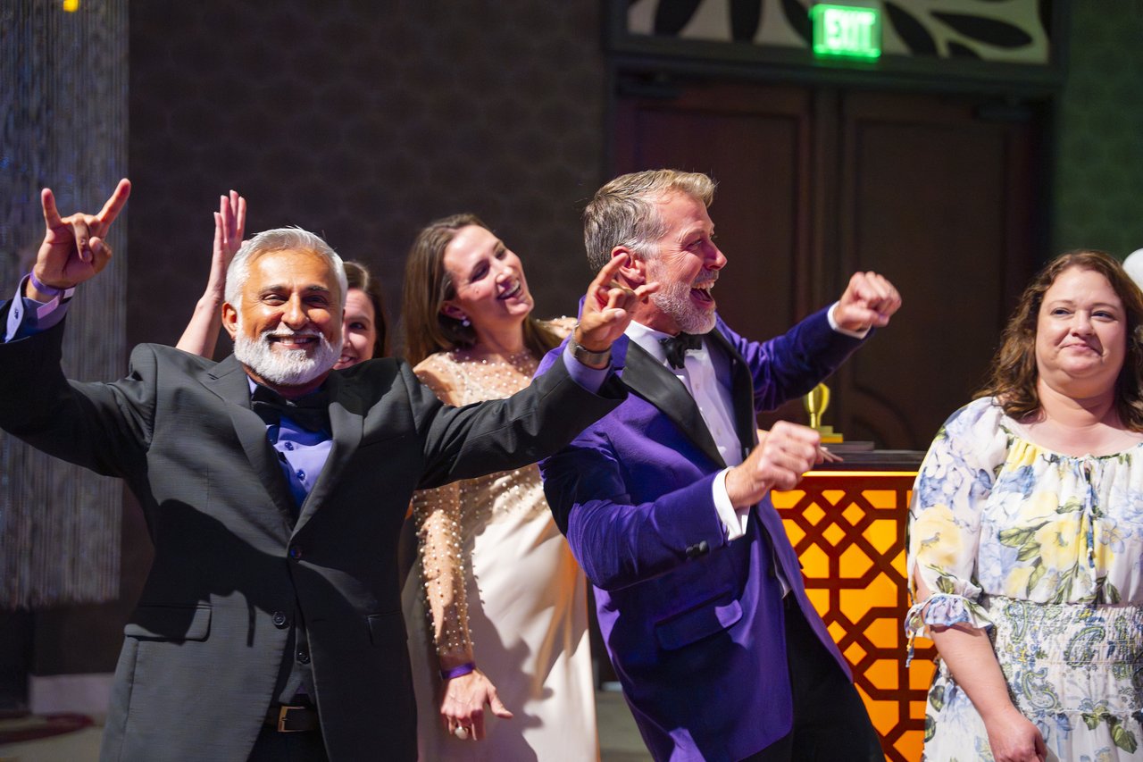 Renown leaders cheering and throwing their hands up on stage