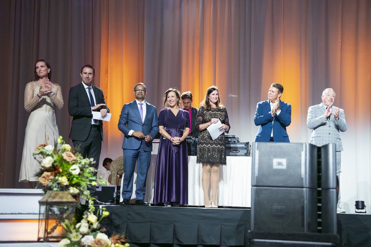 Renown leaders standing in a row and clapping on stage