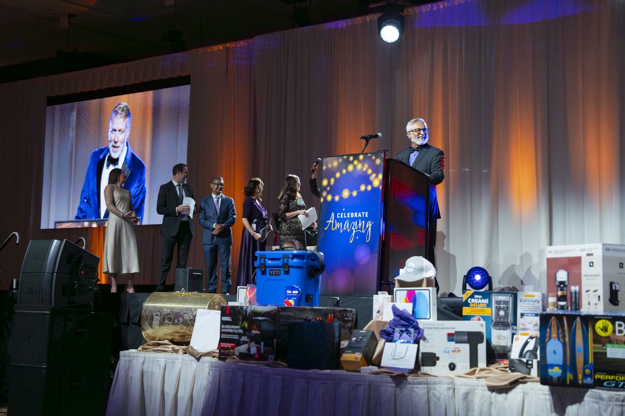 Renown leaders lined up on stage beside the prize table