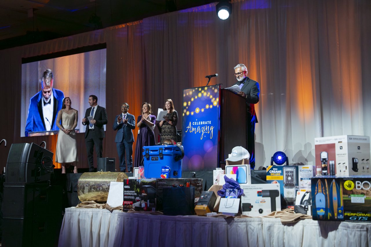 Renown leaders on stage above the raffle prize table
