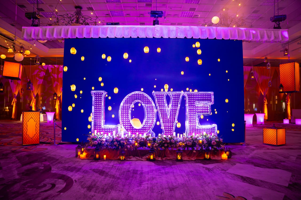 Giant lit LOVE letters in front of a backdrop of floating lanterns