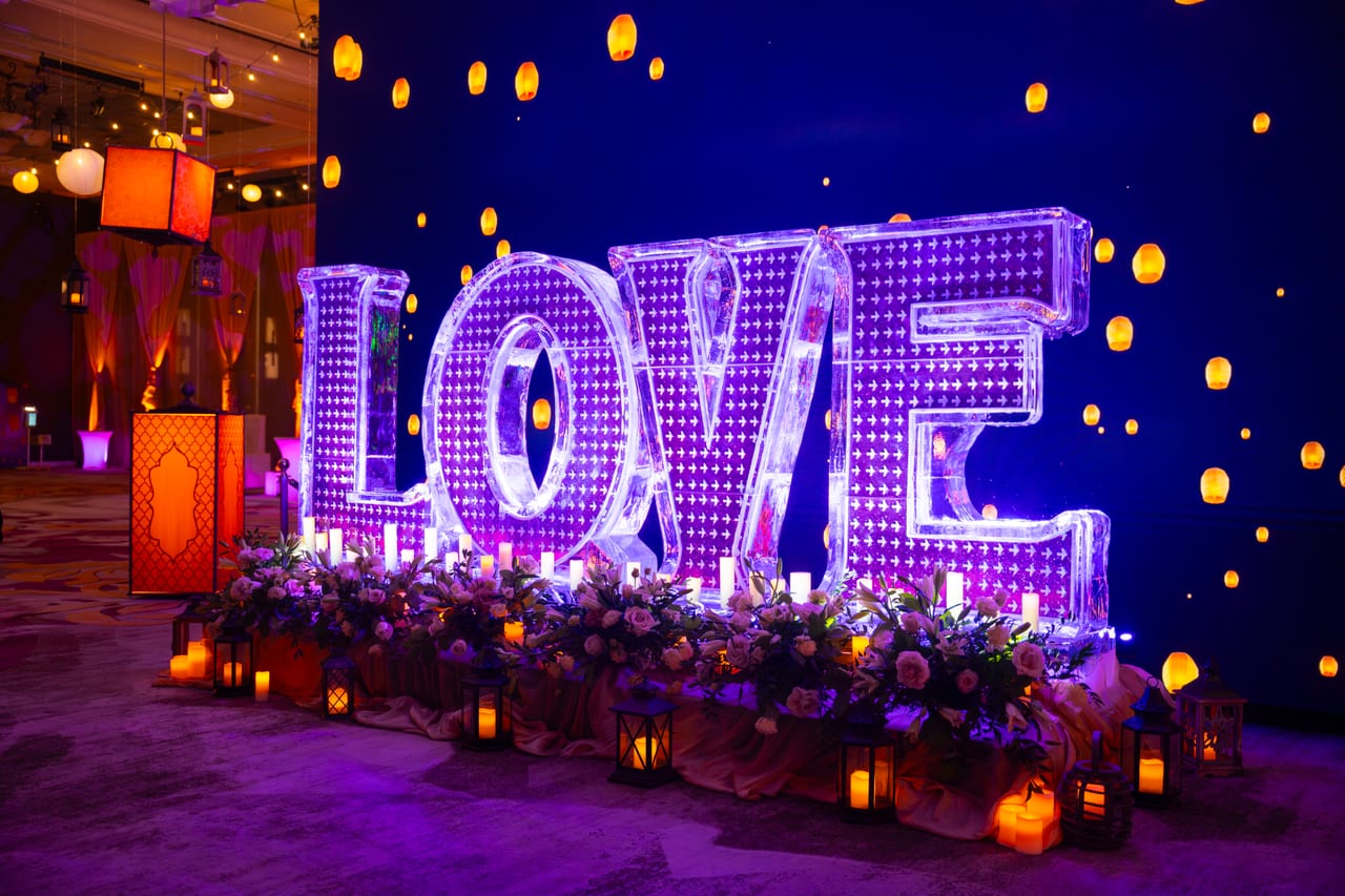 The giant LOVE letters glowing purple among candles and floating lanterns
