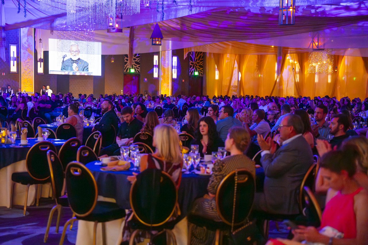 Packed Renown tables applauding a speaker