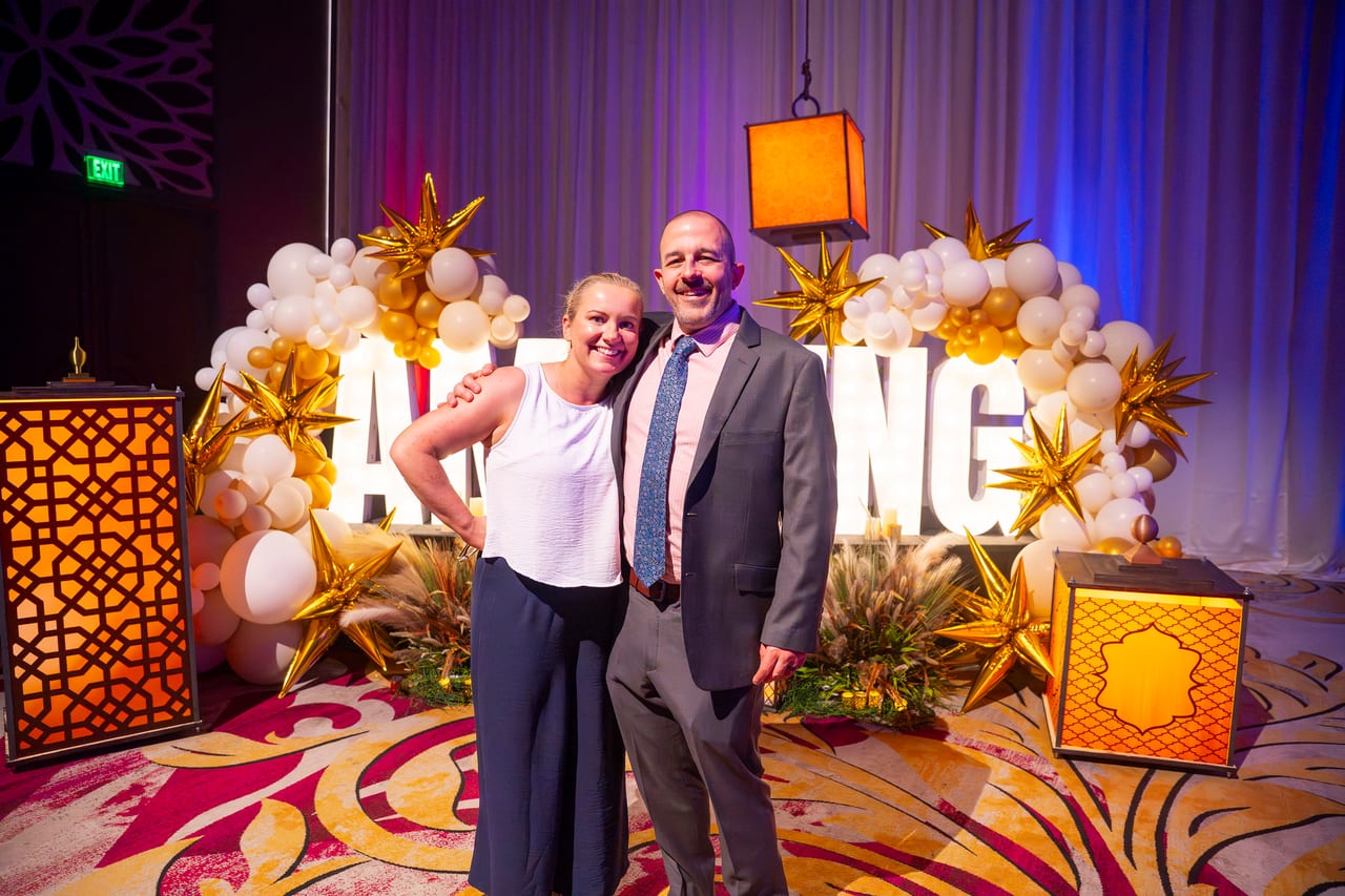 Two Renown coworkers posing between the lanterns at the AMAZING letters