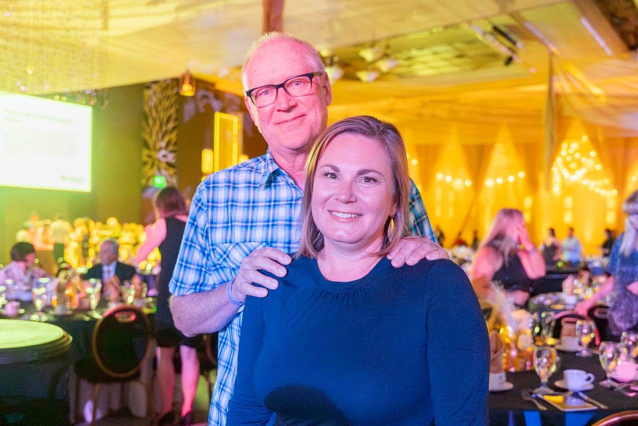 Two Renown guests smiling together by their table in the gold light