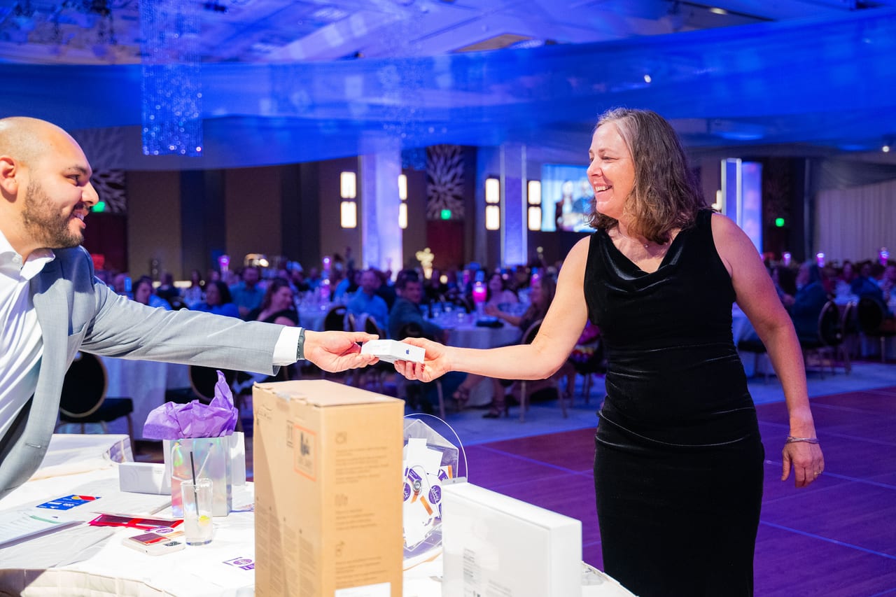 A Renown team member smiling as she takes her prize across the table