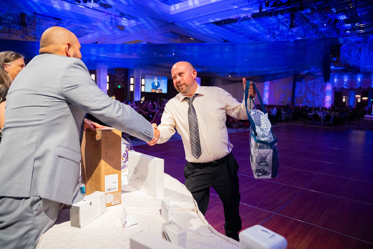 A Renown team member shaking hands as he collects his prize