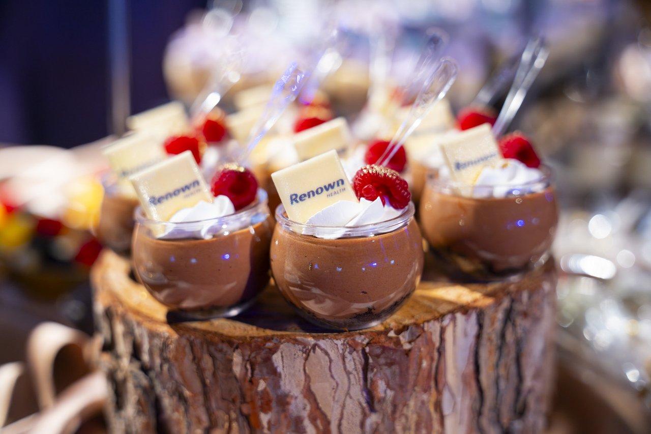 A close up of Renown chocolate dessert cups topped with cream and raspberries