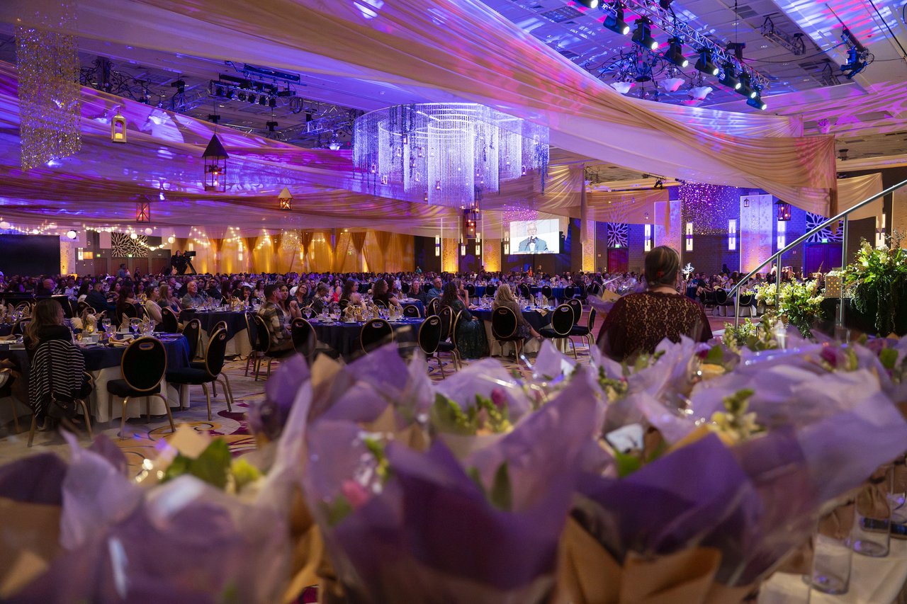 Rows of wrapped bouquets in front of the packed ballroom