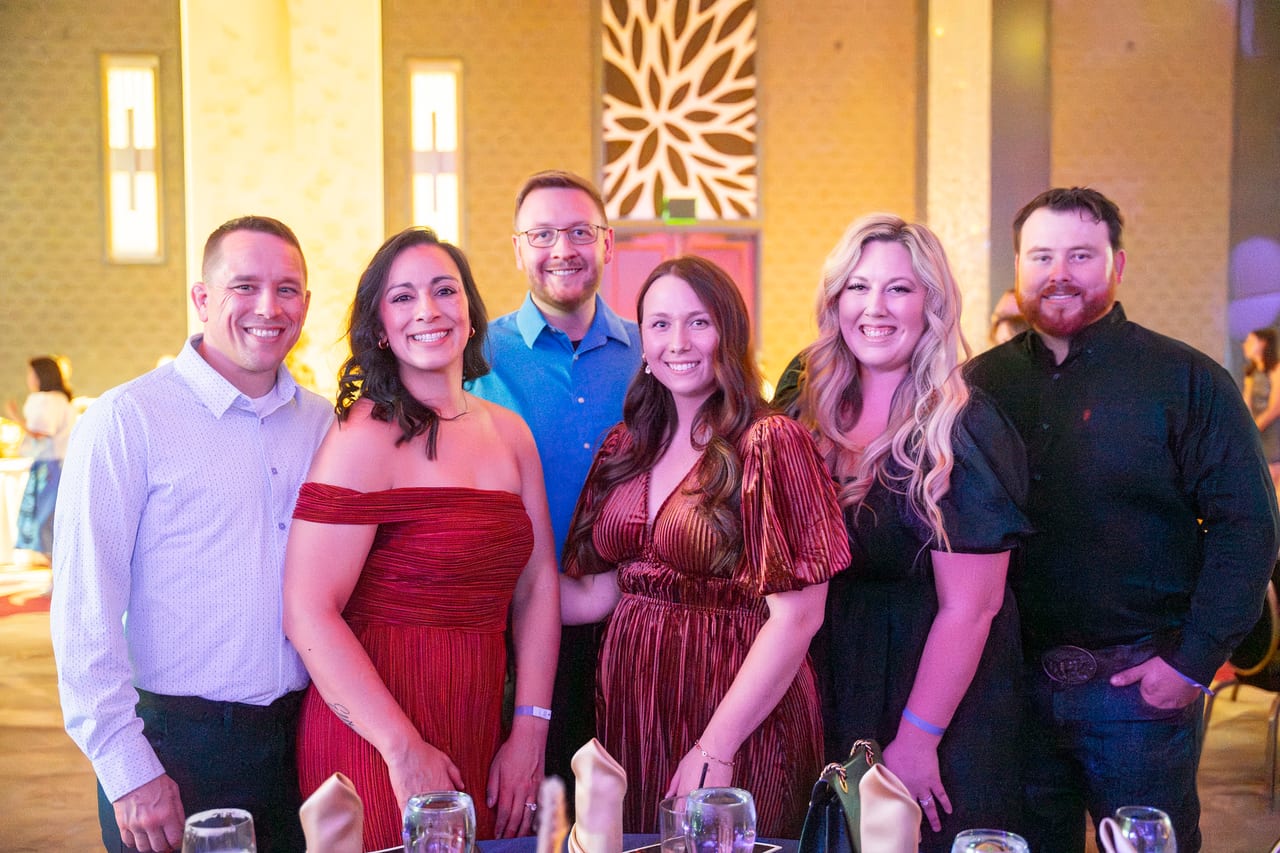 Six Renown coworkers posing together by their table