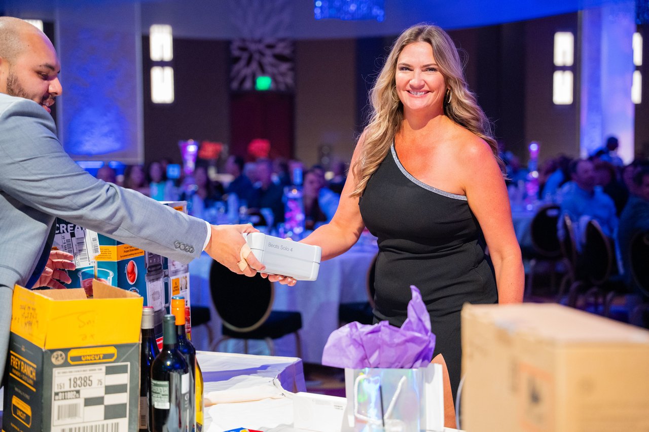 A smiling Renown guest collecting her raffle prize