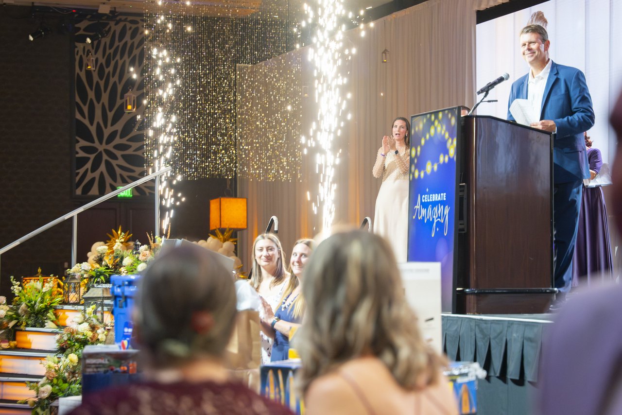 A Renown leader speaking as cold spark fountains light up the stage