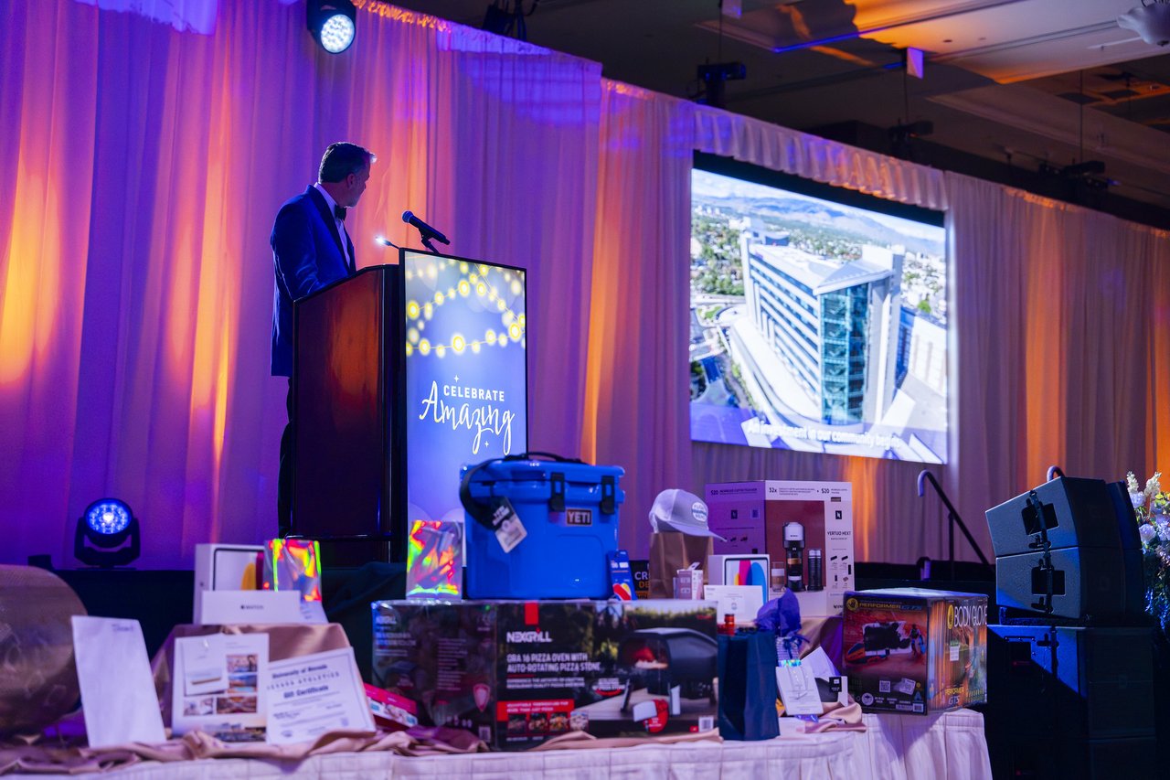 A Renown leader speaking with the hospital shown on the big screen