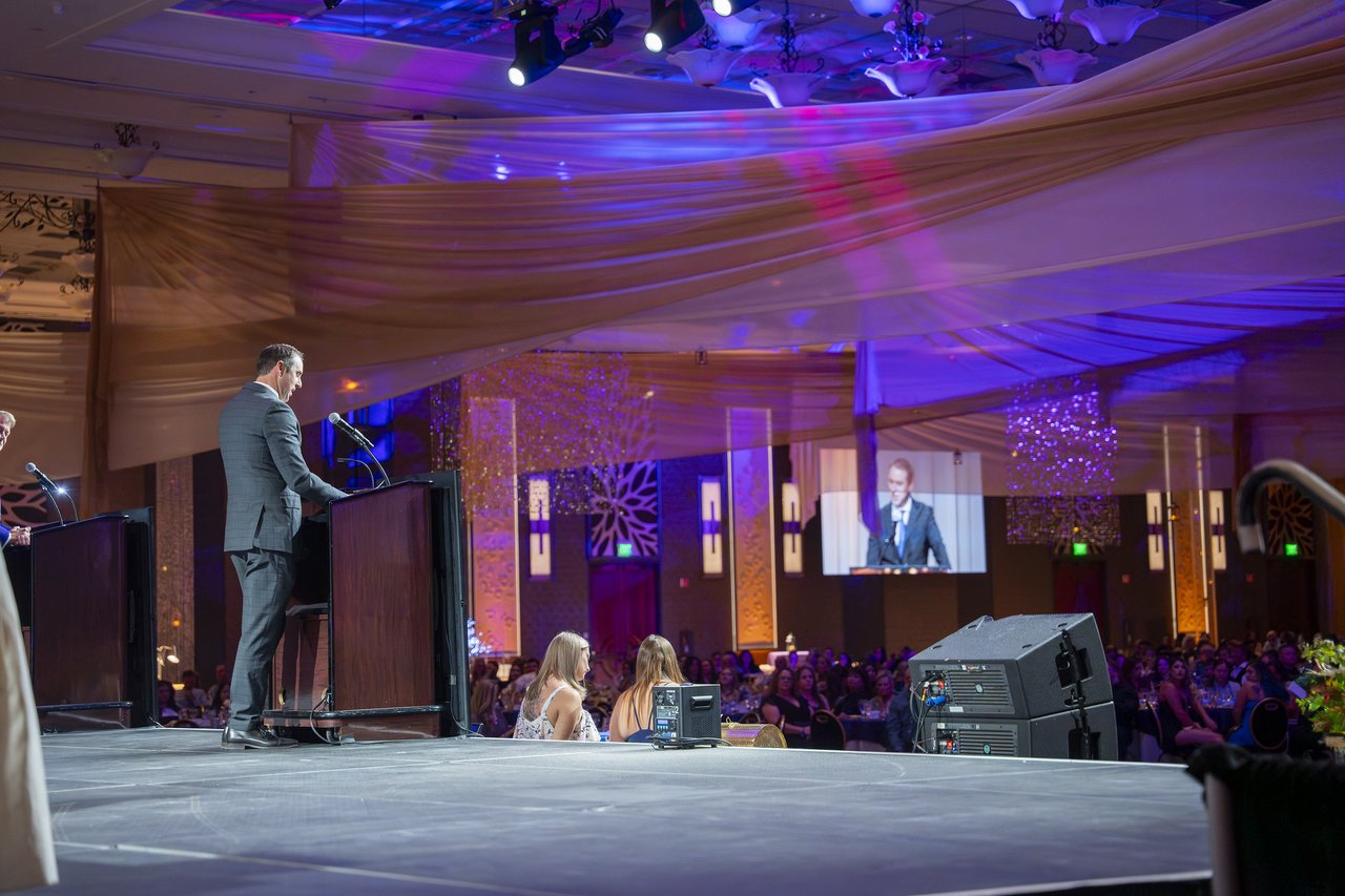 A Renown leader speaking on stage seen from the side