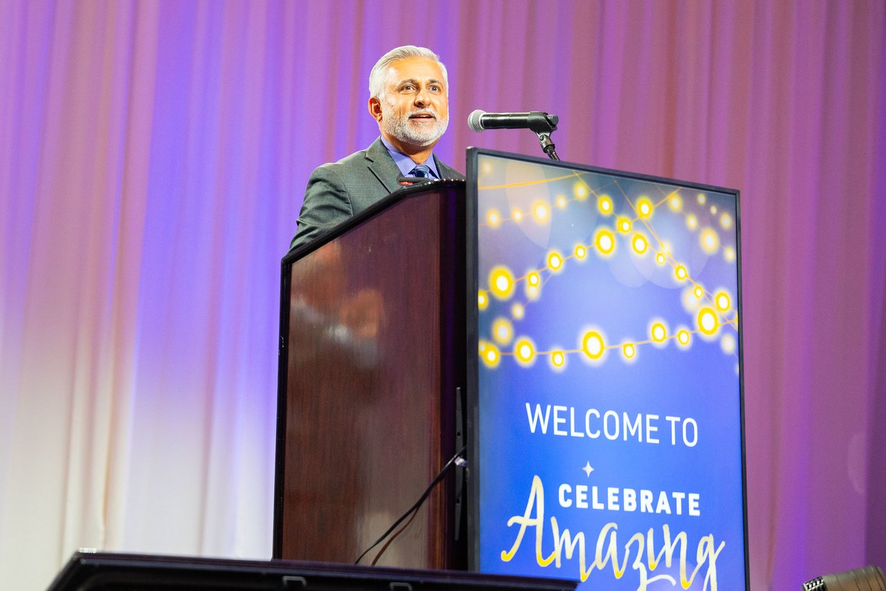 A Renown leader smiling at the Celebrate Amazing podium