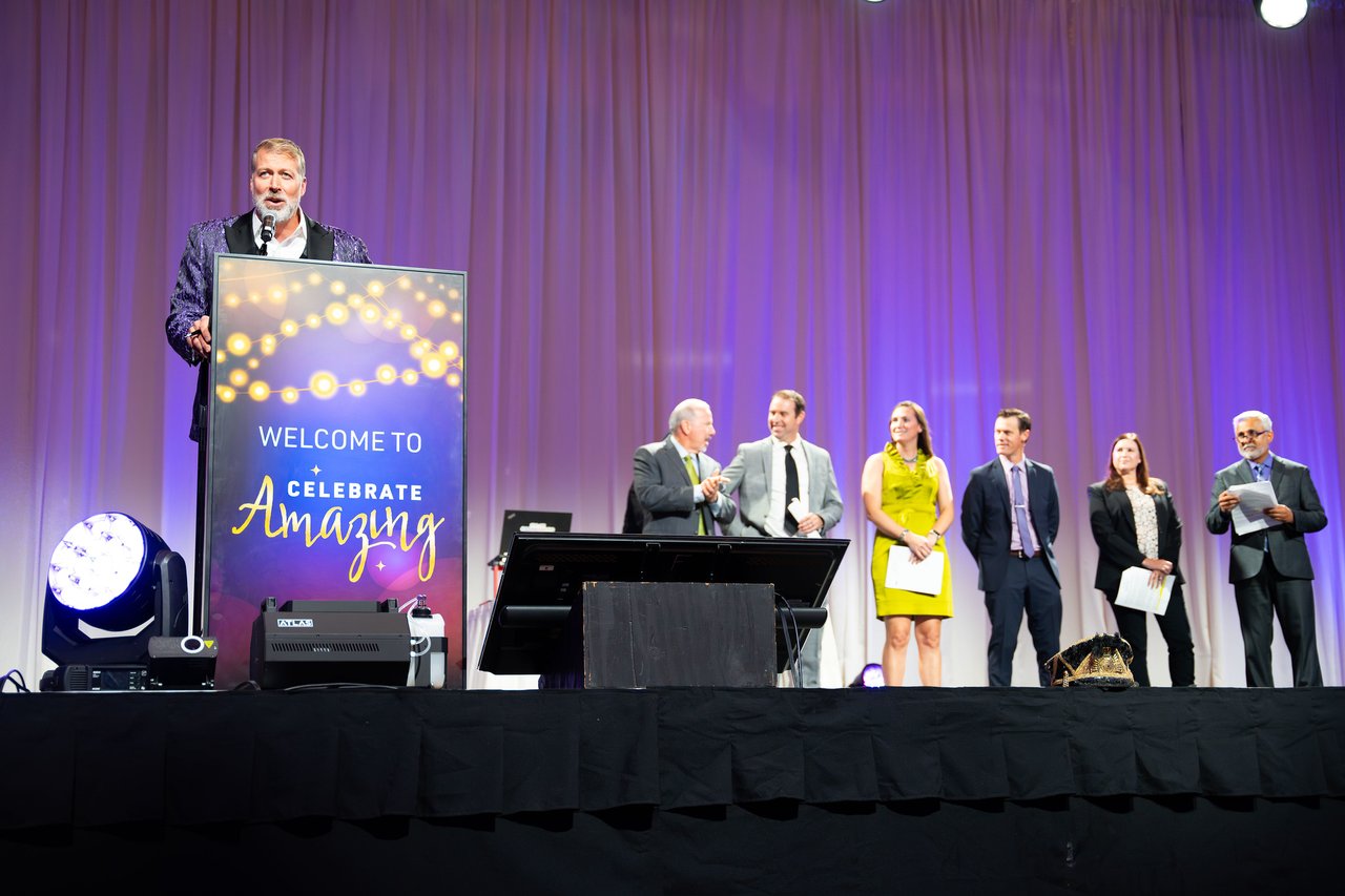 A Renown speaker at the Celebrate Amazing podium with the honorees lined up on stage