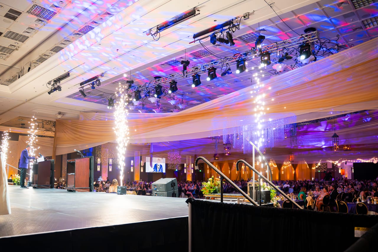 The stage lit by moving lights with cold spark fountains on both sides