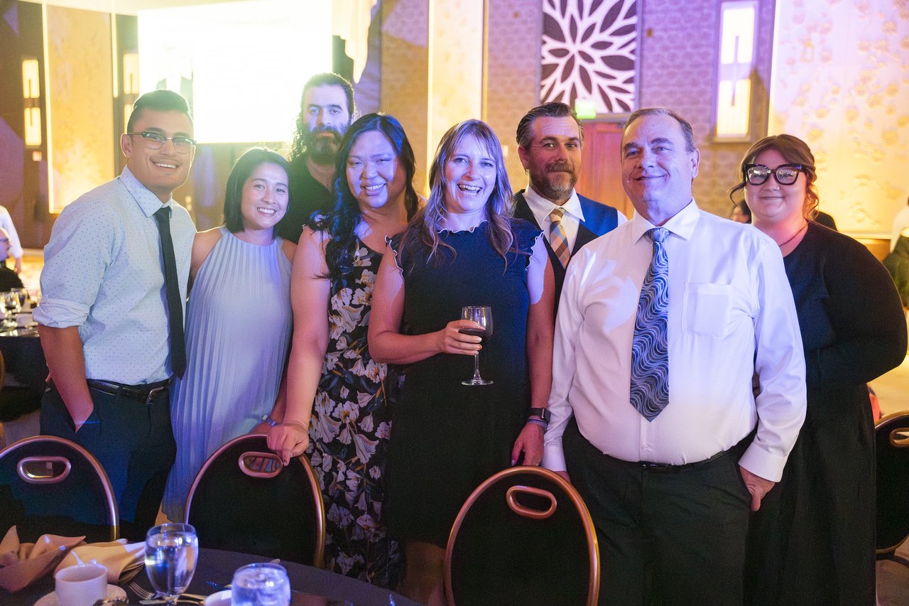 A table of Renown coworkers standing together for a photo