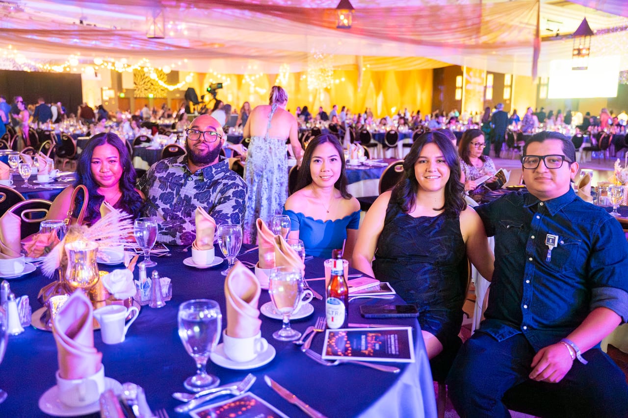 Renown friends smiling around their table before the program